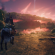 A man on horseback looks out at a landscape lit by hues of pink and purple.